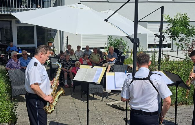 Saxophonquartett vom Landespolizeiorchester spielt für Senioren im Freien