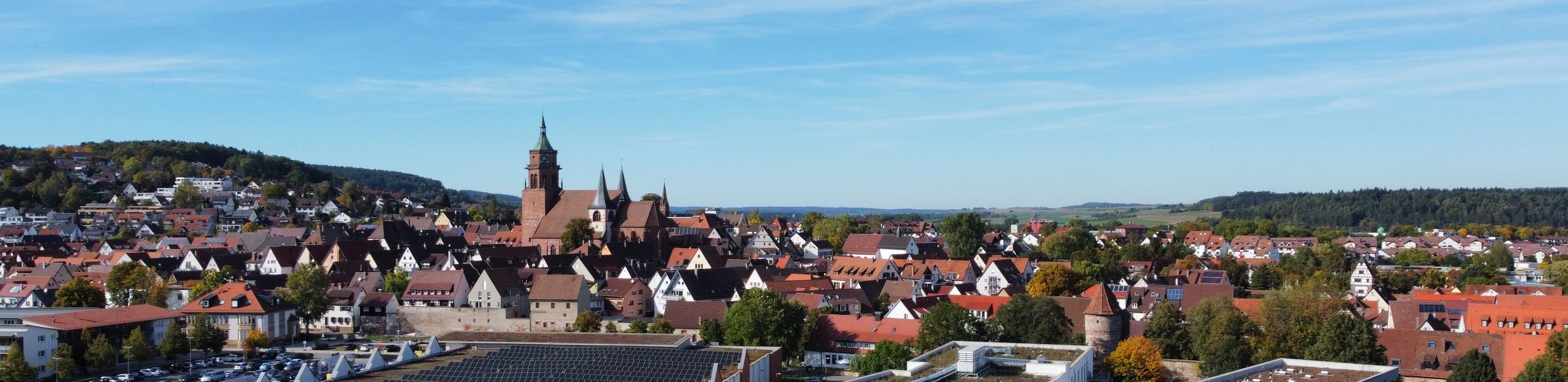 Luftaufnahme einer Kleinstadt mit zentraler Kirche und modernen Gebäuden
