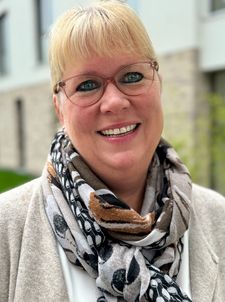 Lächelnde Frau mit transparenter Brille und gemustertem Schal