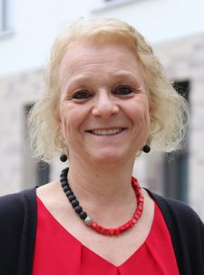 Lächelnde Frau mit roter Bluse und Halskette